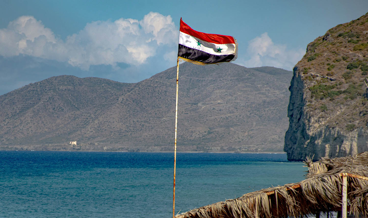 Syrian flag waving over the water